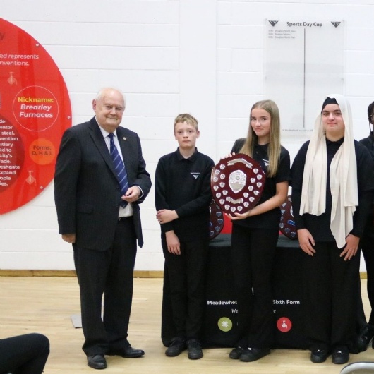 Mr Cook with students holding the Cook shield